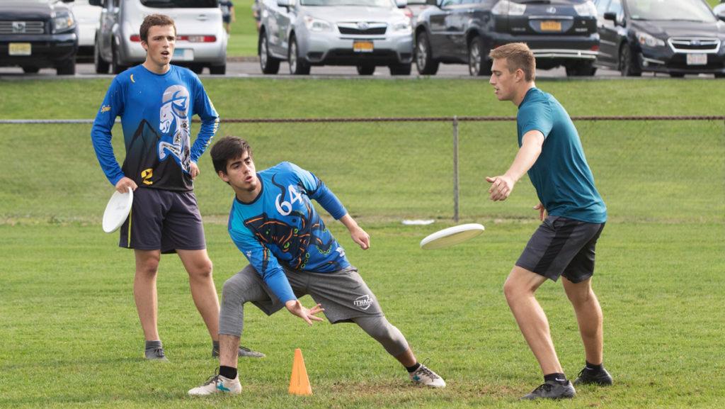 From left to right, sophomore Eli Robinson, senior Jonathon Ramos, and sophomore Ben Gutchess practice for their Ultimate Frisbee tournament on Sept. 28.