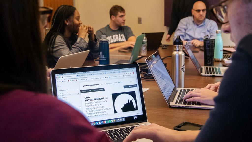 Students convene for their weekly Lynx Entertainment production meeting Oct. 22 in the Ithaca College School of Business. They work on setting up their company and website under the guidance of Phil Blackman, assistant professor in the Department of Accounting and Business Law.