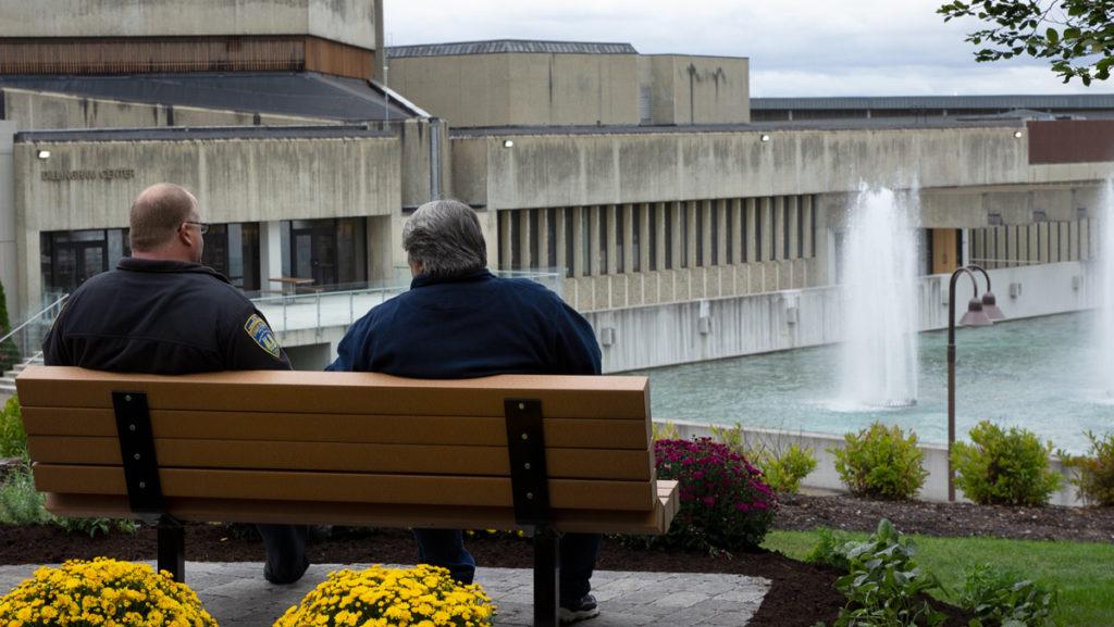 From left, parents Enoch and Debbie Perkins sit on the bench dedicated to Kelly Perkins on Oct. 4. The bench overlooks the Dillingham Fountains and Cayuga Lake, which was one of Kellys favorite spots on campus. 
