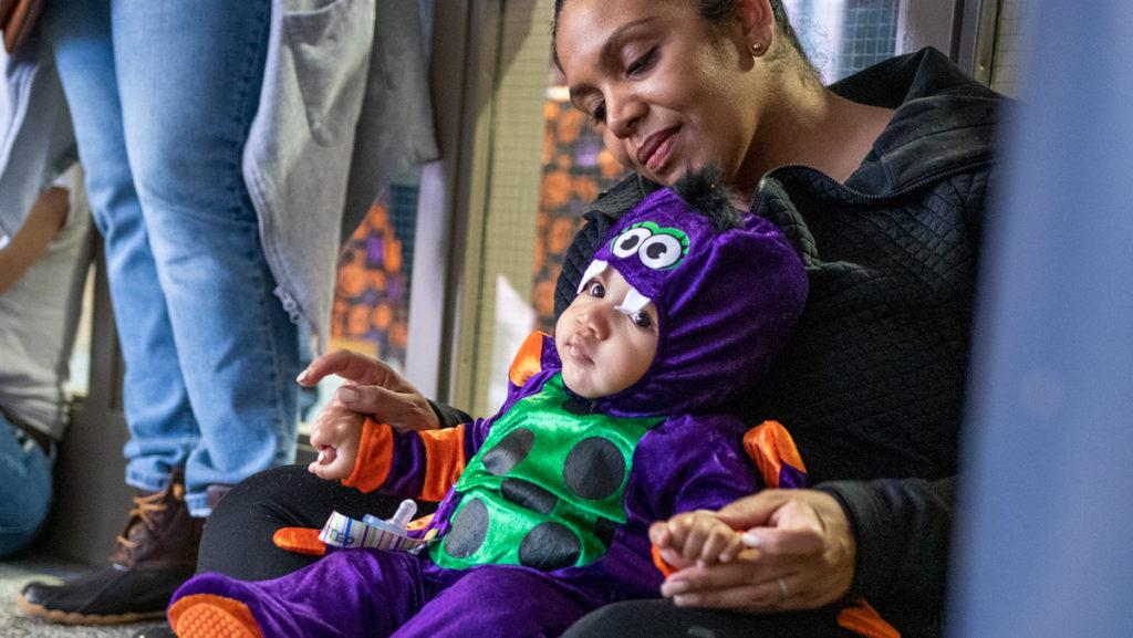 Rosanna Ferro, vice president of the Division of Student Affairs and Campus Life, sits with her son Matteo on Oct. 27 in Emerson Hall. Students decorated their dorms and gave candy to children of Ithaca College faculty and staff at the annual event. 