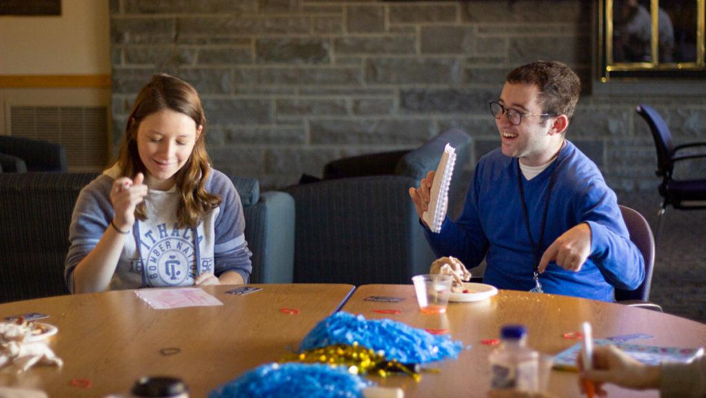 Freshman Grace Madeya and junior Matt Kamen do crossword puzzles at the sensory room viewing party for Cortaca. The event was hosted by DEAR@IC and tactile objects  like crossword puzzles, sudoku, coloring books, stickers, stress balls and weighted blankets were provided to help alleviate stress. 