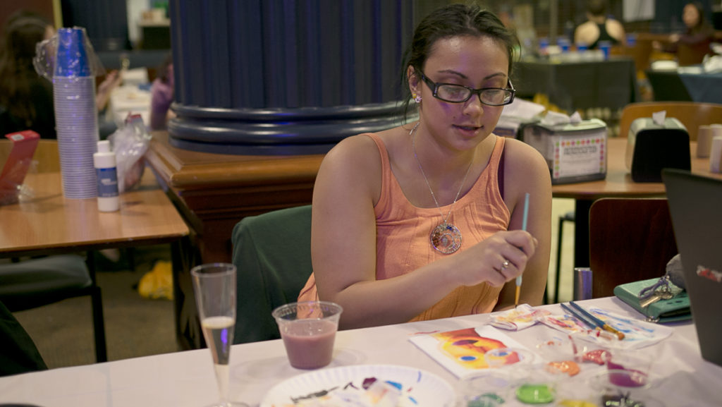 Senior Diana Mejia paints as part of a sip-and-paint event Nov. 1. Students attending the event in IC Square could paint and win prizes. To implement more events, a Campus Center Planning Board was created this semester. 