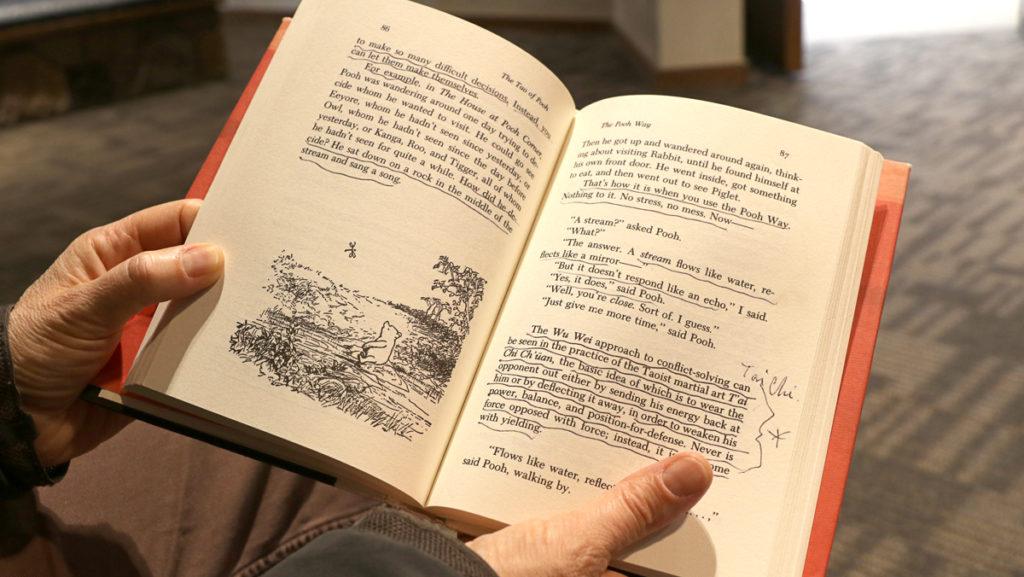 Julia Lapp, associate professor of health promotion and physical education at Ithaca College, holds her copy of The Tao of Pooh, which highlights Taoism and mindfulness. 