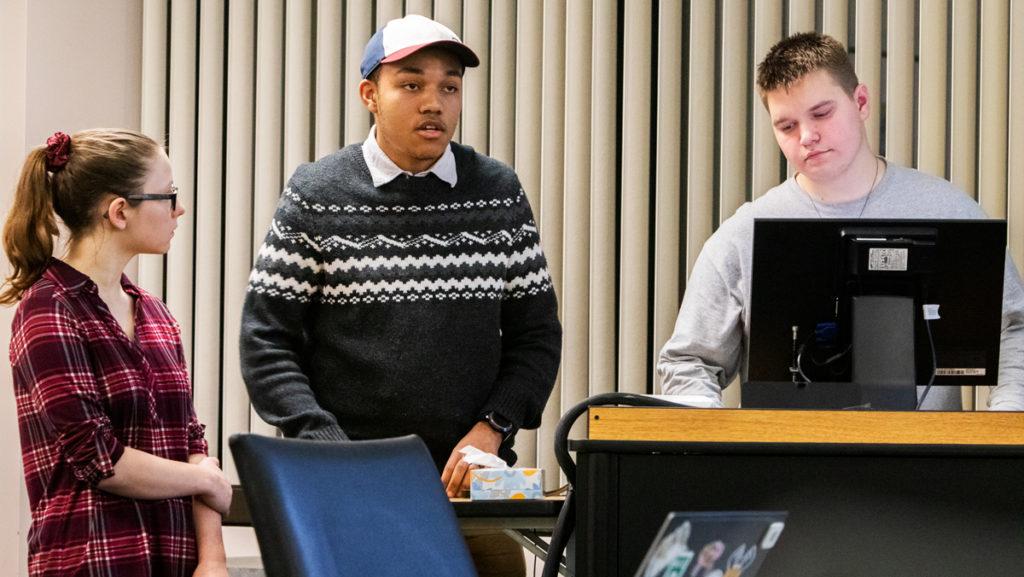 From left, freshmen Grace Madeya and Henry Wade,  Class of 2023 senators, and sophomore Senator-at-Large Maxwell Powers present the Magazine Sustainability Amendment to the Student Governance Council on Dec. 9. 