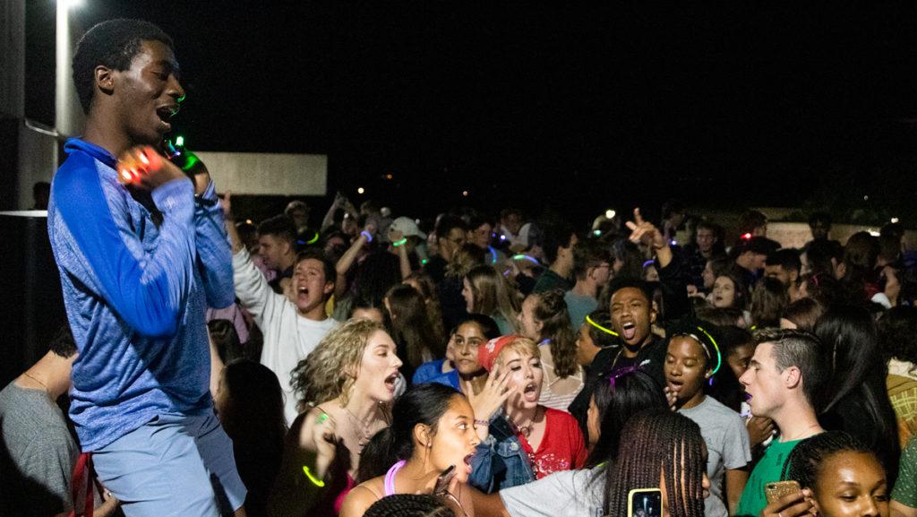 Sophomore orientation leader Mark Gregory rallies the crowd at Club Glow, a dance party and orientation event on Aug. 24 at the Dillingham Fountains.