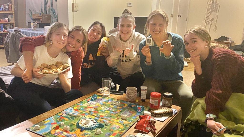 Several members of the womens track and field team enjoy board games and snacks while bonding in upperclassmen housing during winter break.