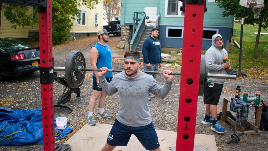 Ithaca+College+junior+football+player+Michael+Roumes+prepares+to+lift+while+working+out+with+his+roommates+and+teammates+in+their+at-home+gym