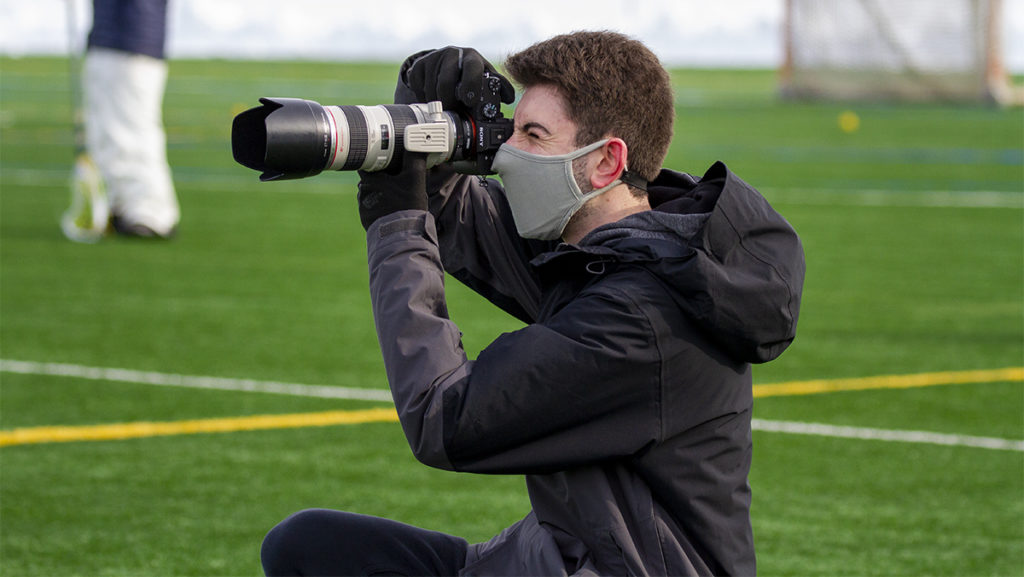 Sophomore Peter Raider shoots multimedia content at a women’s lacrosse practice for the IC Athletics social media Feb. 10 at Higgins Stadium.