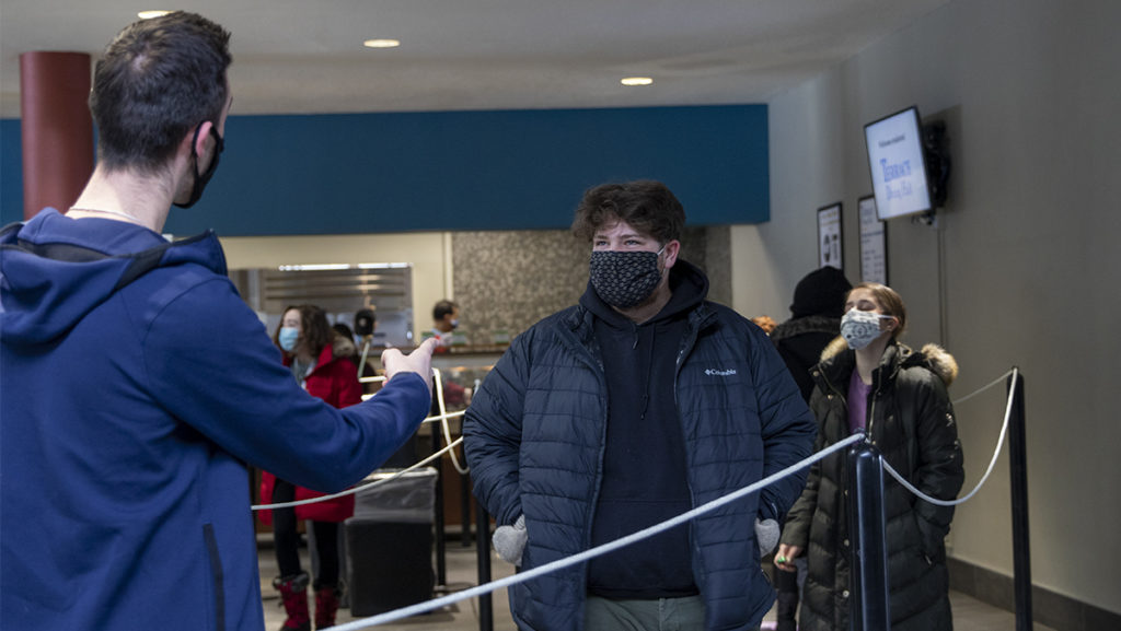 From left, sophomores Liam Spellman and Samuel Levine wait in line on the social distancing markers at Terrace Dining Hall on Feb. 9.