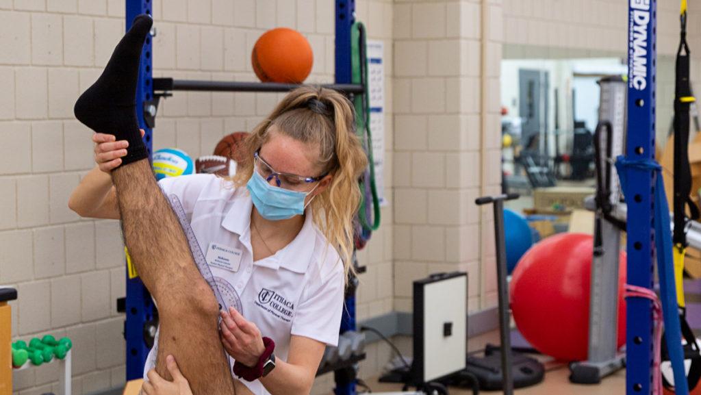 Junior McKensie Galusha, a physical therapy student, treats a patient at the Ithaca College Physical Therapy Clinic in the Center for Health Sciences. The physical therapy clinic, among others, has opened for limited in-person operations for Spring 2021.