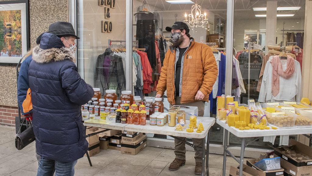 Alex Reynolds from Waid's Honey stands at his booth, selling products like honey and candles March 6 at the Winter Farmers Market. The Winter Market is open 10:30 a.m.–2 p.m. each Saturday until March 27 at the Triphammer Marketplace.