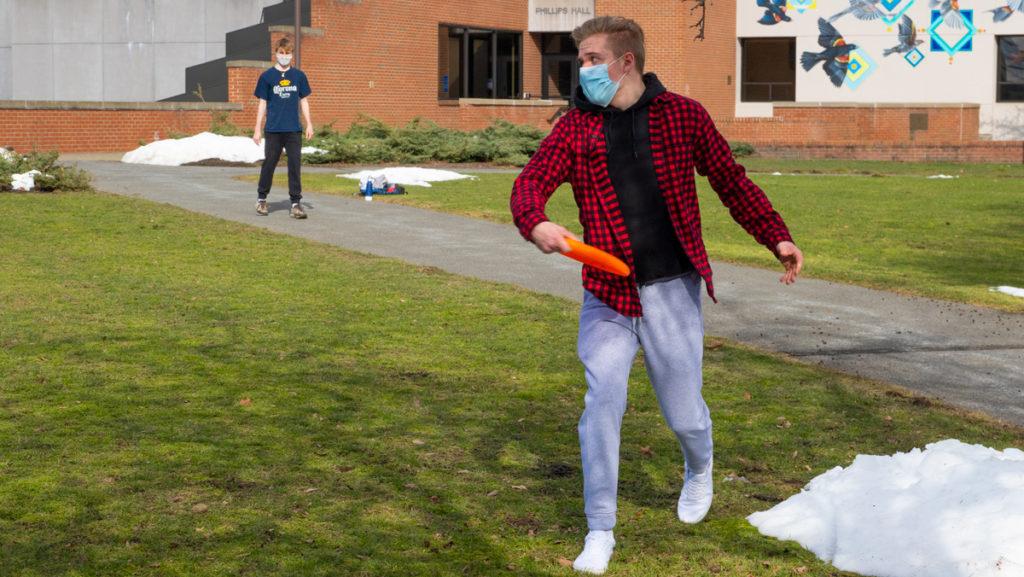From left, freshmen Liam Kirby and Jason Demers celebrate the arrival of spring weather by playing frisbee Feb. 27 outside of Phillips Hall. Ithaca had a high of 43 degrees Feb. 27, allowing many students to spend time outside.