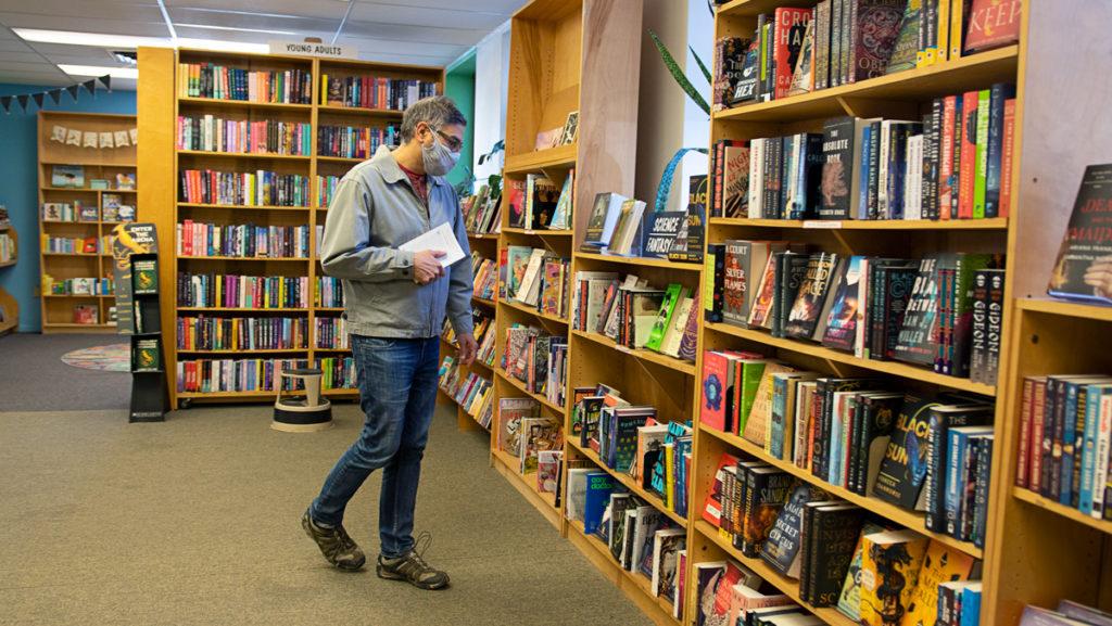 Ithaca resident Mahinder Kingra browses for books in the science fantasy section at Buffalo Street Books on April 3.