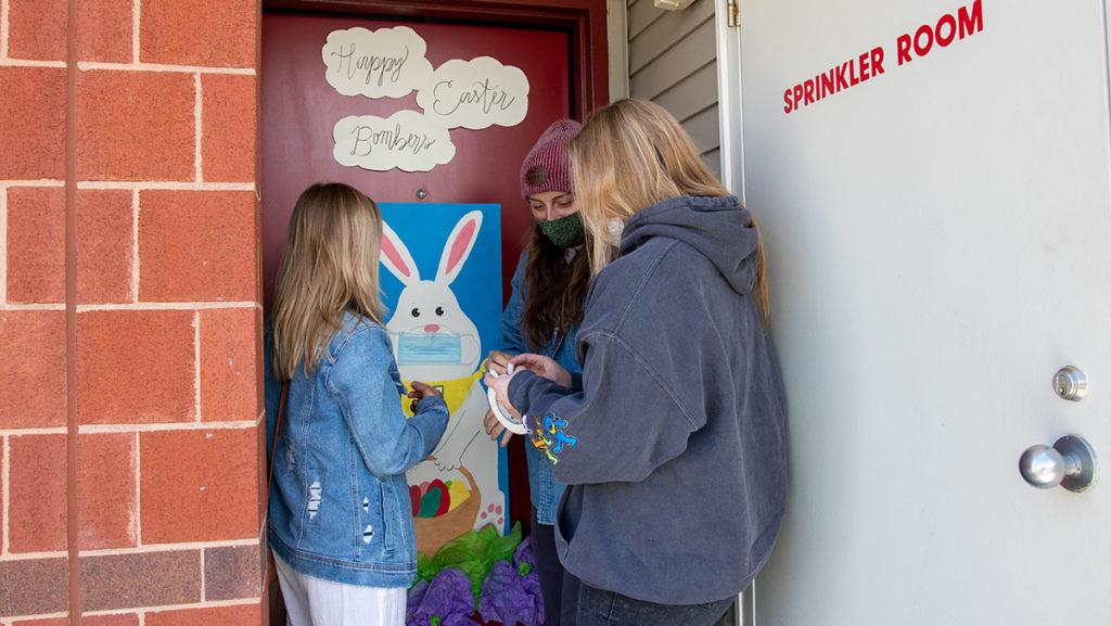From left, juniors Morgan Mullen, Grace Ziehnert and Allison Egan decorate their Circle Apartment's door for the Deck Your Door event April 3. A viewing of the doors was held from 2–4 p.m. April 3 and voting was online and in person.