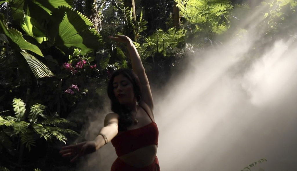 Junior Gaby Tola, artistically known as neptunemuse, dances in a botanical garden in Miami for the Jungle Flame video.