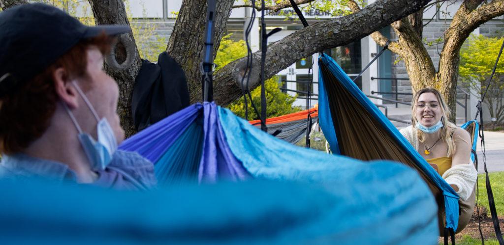 From left, freshmen Tyler Hanna and Delaney Judson set up their hammocks in the shade April 27 outside of Hammond Health Center.
