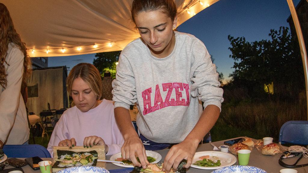 From left, juniors Jade Rynar and Francesca Infante-Meehan roll homemade sushi rolls Sept. 24 outside of Muller Chapel. Hillel at Ithaca College built a Sukkah for the Jewish harvest holiday of Sukkot and held a sushi-making event.