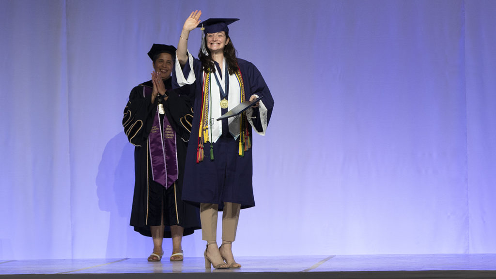 Catherine Fiore 21 walks across the stage in the Glazer Arena in the Athletics and Events Center and the Class of 2021 graduation.