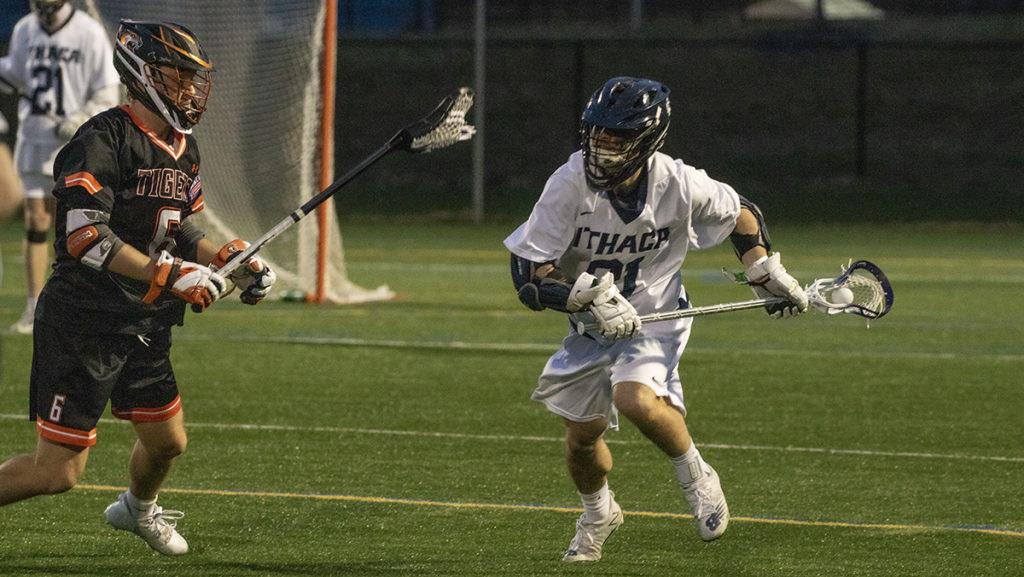 Senior midfielder Willy Wright advances the ball by going past junior defender Luke Pilcher in the Ithaca College mens lacrosse teams 19–6 loss to Rochester Institute of Technology on April 13.