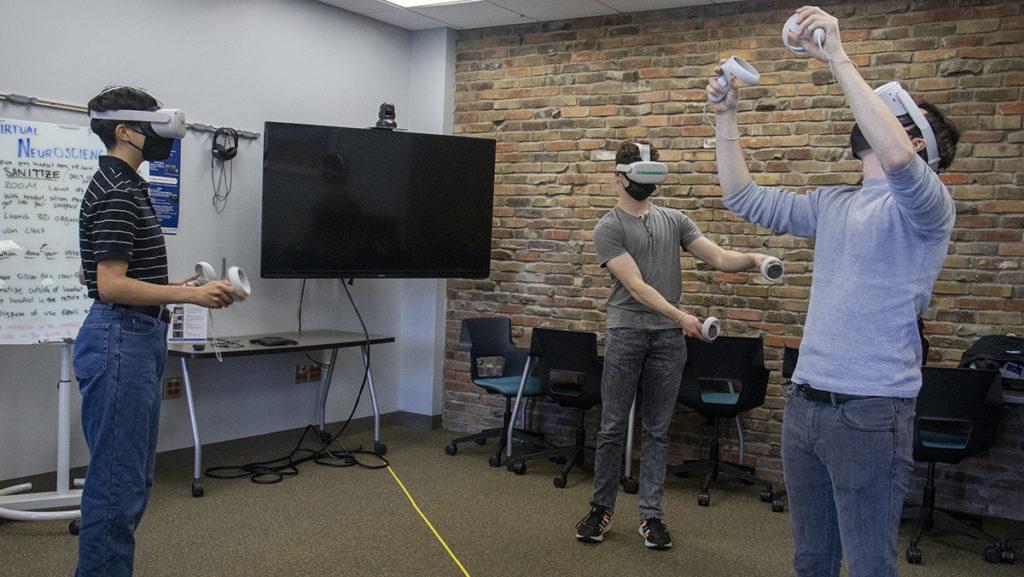 From left, juniors Wren Andujar, Rowan Buck and Sean Fiske use virtual reality (VR) technology provided by IC Immersive, which allows students and professors to use the colleges VR equipment.
