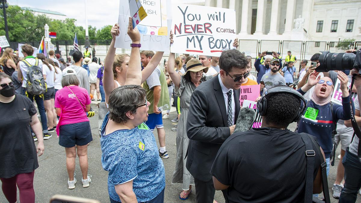 Pro-abortion rights protesters chanted "my body, my choice" while a man with a pro-life sign was doing an interview outside the Supreme Court on June 24. Eleanor Kay/The Ithacan