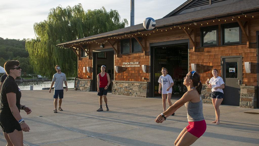 Members of the Ithaca College men’s and women’s rowing teams playing volleyball outside the Ward Romer Boathouse on the Cayuga Inlet on Aug. 18, where the members met weekly for cookouts.