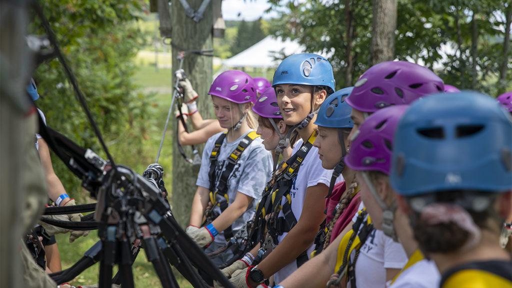 Junior Giana Haubrich prepares for the ropes course with her teammates Aug. 28 at Greek Peak Mountain Resort. The women’s cross-country team spent time bonding before the season.