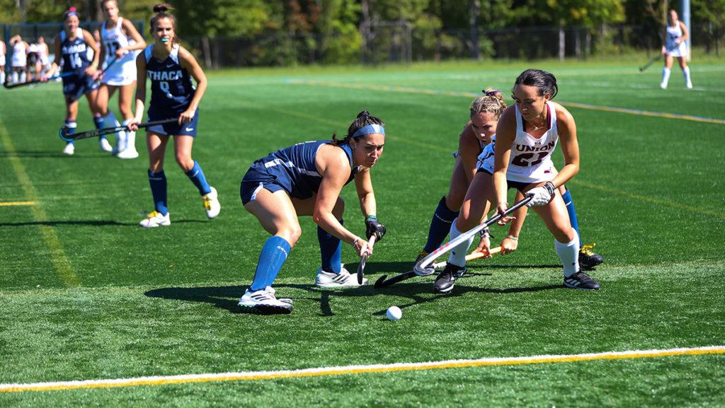 From left, sophomore striker Natalie Descalo and junior striker Sarah Devito of the Bombers, and junior defender Ali Barrett of the Dutchwomen fight for a ball during the Ithaca College field hockey teams 3–0 victory over Union College Sept. 24.