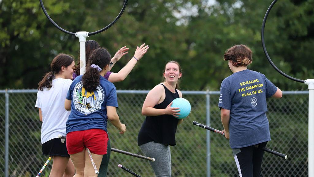 First-year student Claudia Homiski, a member of Ithaca Hex Quidditch, holds the quaffle while teammates and opponents surround her. Her goal is to throw it through one of the three hoops, while her opponents, called beaters, try to block it.