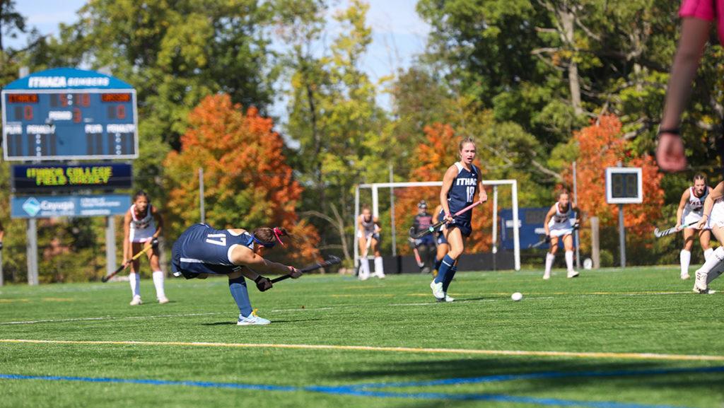 From left, sophomore defender Madeline Goodman passes the ball as sophomore midfielder Meara Bury trails the play during Ithaca College field hockey team 1–0 victory over Vassar College.