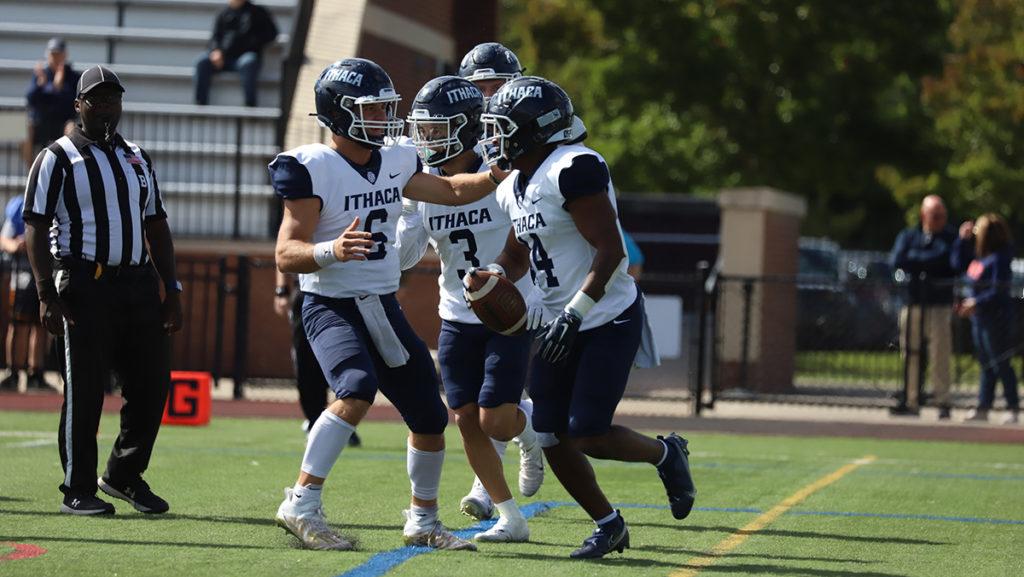 From left, senior quarterback A.J. Wingfield, senior wide receiver Michael Anderson and junior running back Jalen Leonard-Osbourne celebrate during the Ithaca College football teams victory over Hobart College on Oct. 1.
