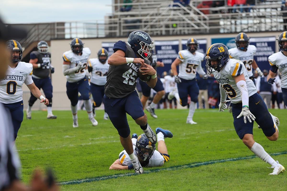 Junior running back Jake Williams tries to escape from a defender while University of Rochester sophomore Jack Yensel closes in for the tackle. Brendan Iannucci/The Ithacan