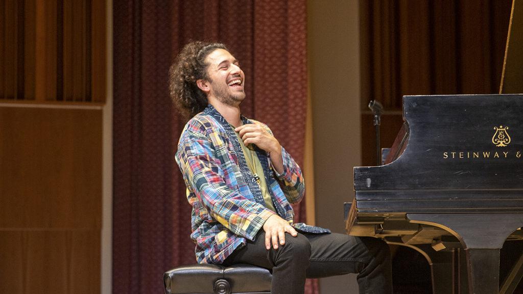 Jazz musician Emmet Cohen, of the Emmet Cohen Trio, laughs after playing a piece during his performance in Ford Hall in the James J. Whalen Center for Music. Cohen was accompanied by Kyle Poole and Yasushi Nakamura.