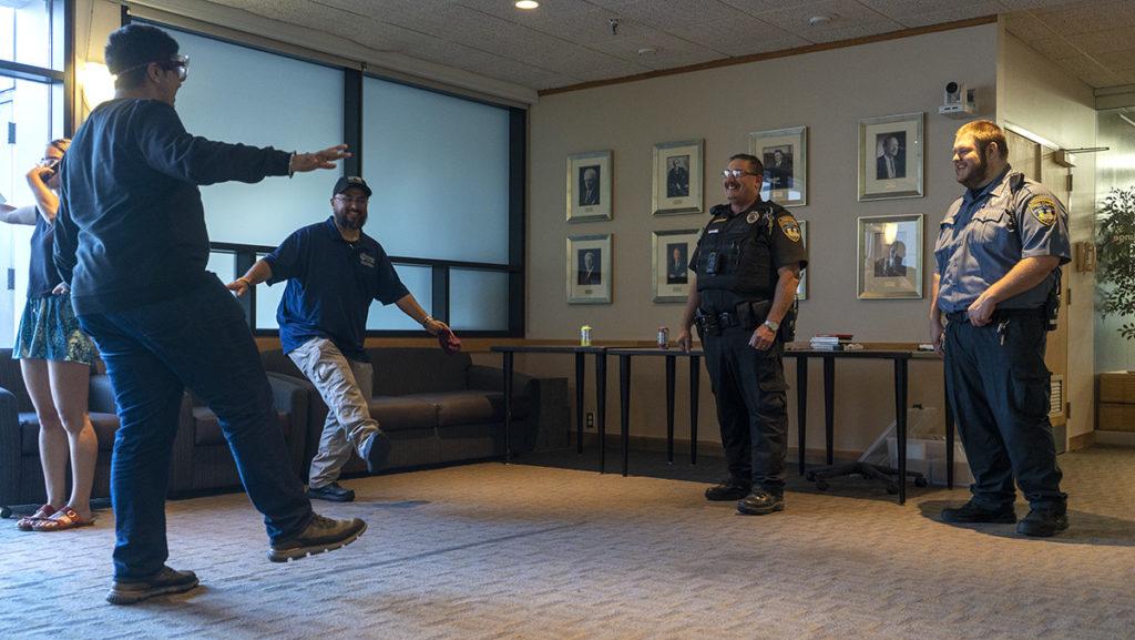 From left, junior Utkarsh Maini, Jimmy Martinez, security officer in the Office of Public Safety and Emergency Management (OPS), and Robert Jones, master patrol officer in OPS, participate in a walk-and-turn test wearing drunk goggles.
