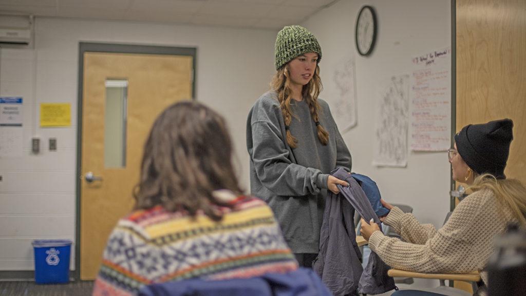 Sophomore Eleanor Wester, the risk management coordinator for the Ithaca College Outing Club, shows sophomore Julia Freitor the difference in material between trekking pants and rain pants during their backpacking workshop Oct. 4. Jasmine Scriven/The Ithacan