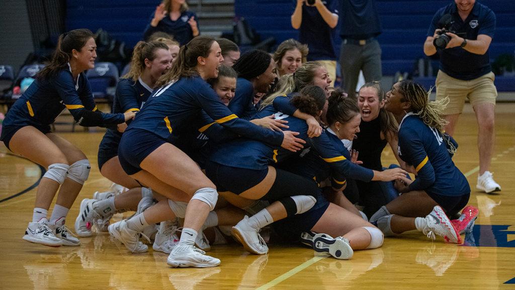The Ithaca College volleyball team celebrates on the court after winning its first conference championship since 2016 with a five-set victory over Clarkson University on Nov. 5.