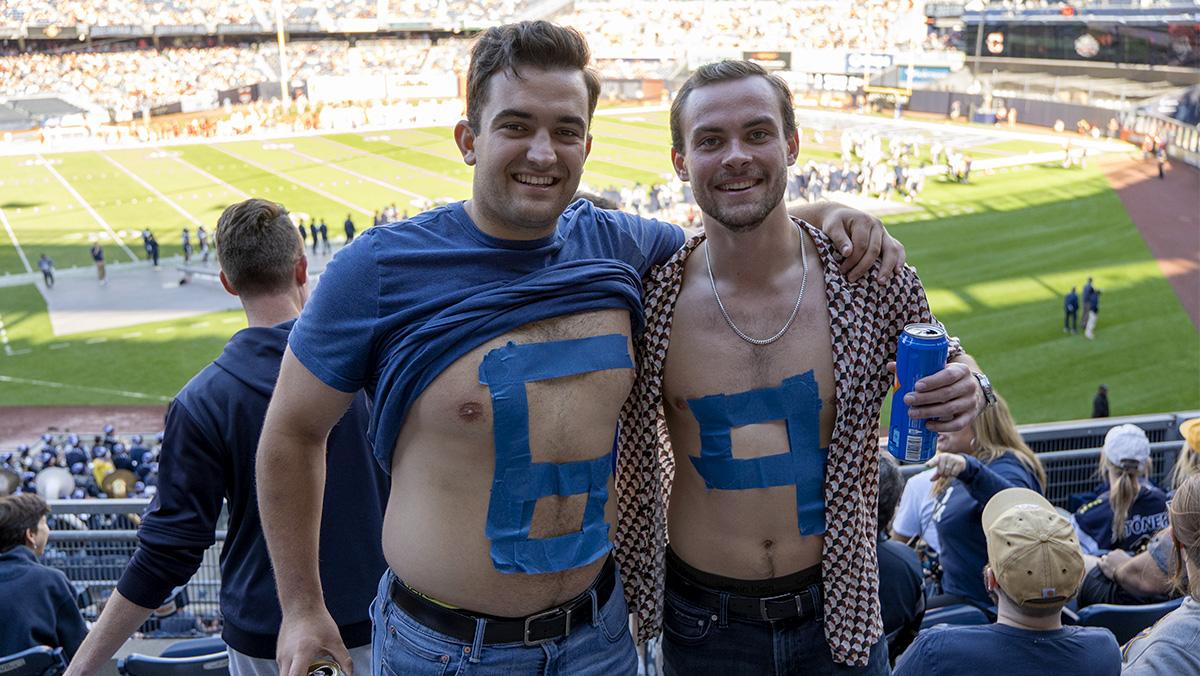 From left, Ithaca College alumni Steven Travaglini and Jared Gillis '21 show their support for senior offensive lineman Joe Arico at the 2022 Cortaca Jug game. LEILA MARCILLO-GOMEZ/THE ITHACAN
