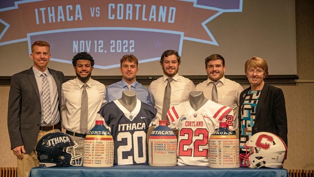 Members of the Ithaca College football team pose in front of the Cortaca Jugs on Nov. 9 during a joint press conference with SUNY Cortland.