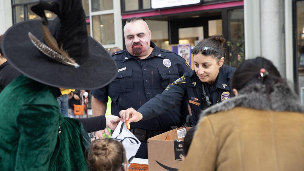 From left, Ithaca Police Department officers Chance Vancleef and Mary Orsaio gave candy to trick-or-treaters during the downtown celebrations Oct. 28.