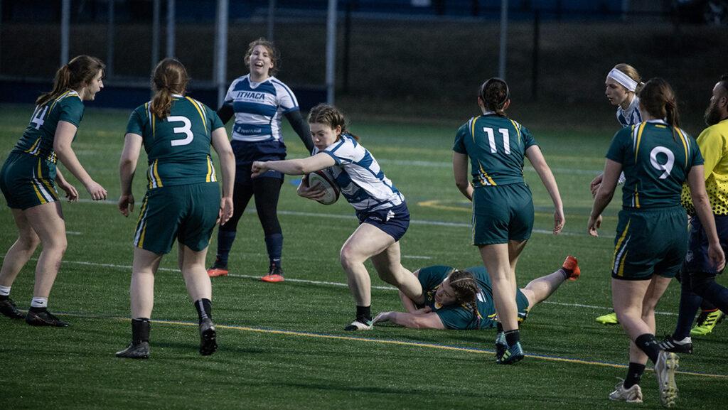 Ithaca College first-year student Clare Jordan runs through Clarkson University senior Kelly Boutin as Ithaca first-year student Taylor Piergrossi waits for a pass. Ithaca College Women’s Club Rugby placed second in the tournament April 1. 