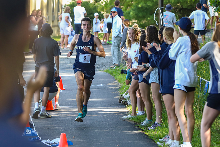 Senior Patrick Bierach nears the finish line while spectators look on and cheer. Bierach earned a first-place finish on the mens side of the race with a 5k time of 16:51.98.