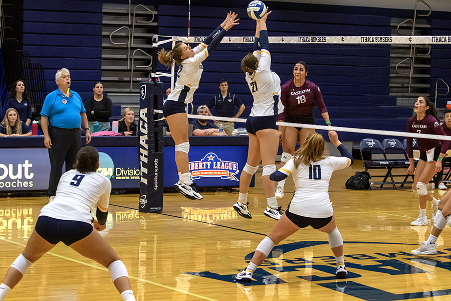 From left, junior outside hitter Samantha Klemm and junior defensive setter Peyton Miller look on while sophomore middle blocker Ella Graper and first-year outside hitter Naomi Clauhs go up for the ball.
