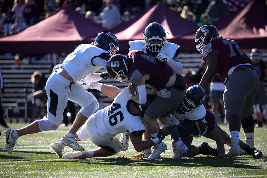Springfield junior quarterback Jacob Silvester is stopped by several Ithaca College Bombers defenders during their NCAA tournament game Nov. 18. The Bombers would go on to defeat the Pride, 21–7.