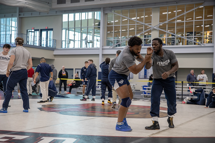 From left, assistant coach Eze Chukwuezi 23 and junior Xavier Pommells train together in the Glazer Arena. The Ithaca College wrestling teams coaching staff is made up entirely of program alumni.