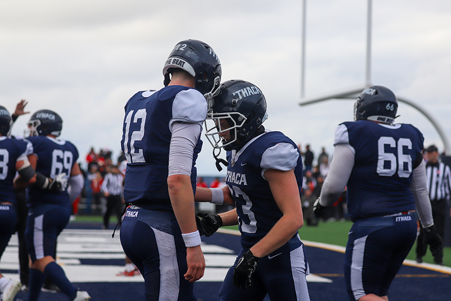 From left, first-year quarterback Colin Schumm bumps helmets with senior wide receiver Sam Kline after the two connected for a touchdown.