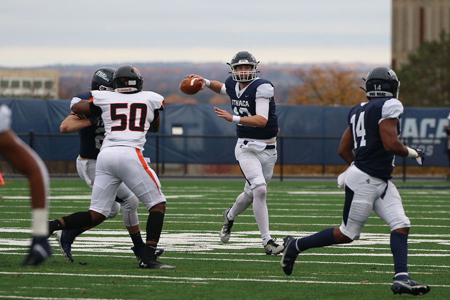 From left, Buffalo State sophomore defensive end Nicholas Moore looks to get around a block as first-year quarterback Colin Schumm loads up to send a pass to senior running back Jalen Leonard-Osbourne.