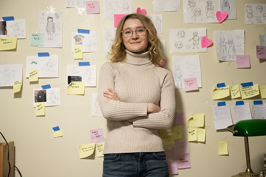 Senior Violet Van Buren stands in her room in front of a wall of drawings and designs for her animated series, Gnome Homes, she did for an animation company, Channel 101.