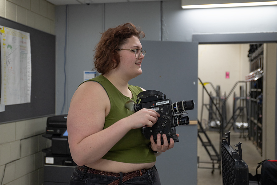 Junior Ainsley Perkins inspecting a Bolex film camera, most often used in Cinema Production classes, as a Park Portable Equipment (PPECS) employee. 