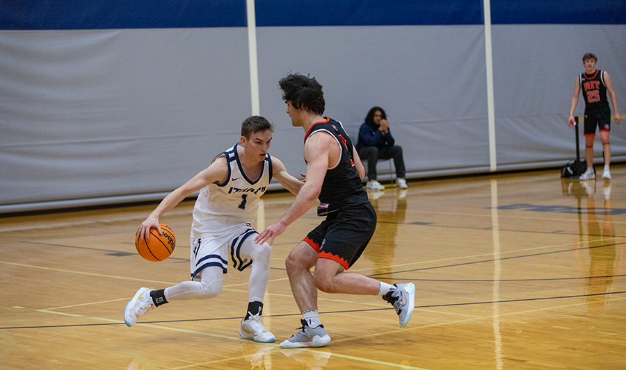 Junior guard Logan Wendell goes with a behind the back dribble against RIT senior guard Keegan Ocorr.
