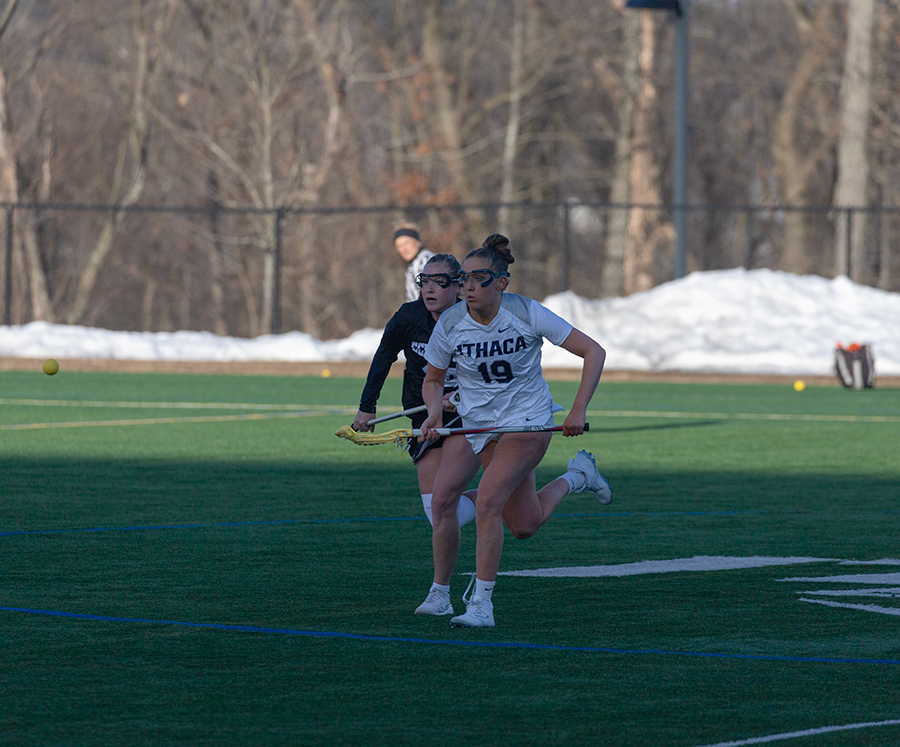 Senior midfielder Caroline Wise runs after the ball while being chased by a Royals player. The Bombers ran away with a 13–9 victory after trailing in the first half.